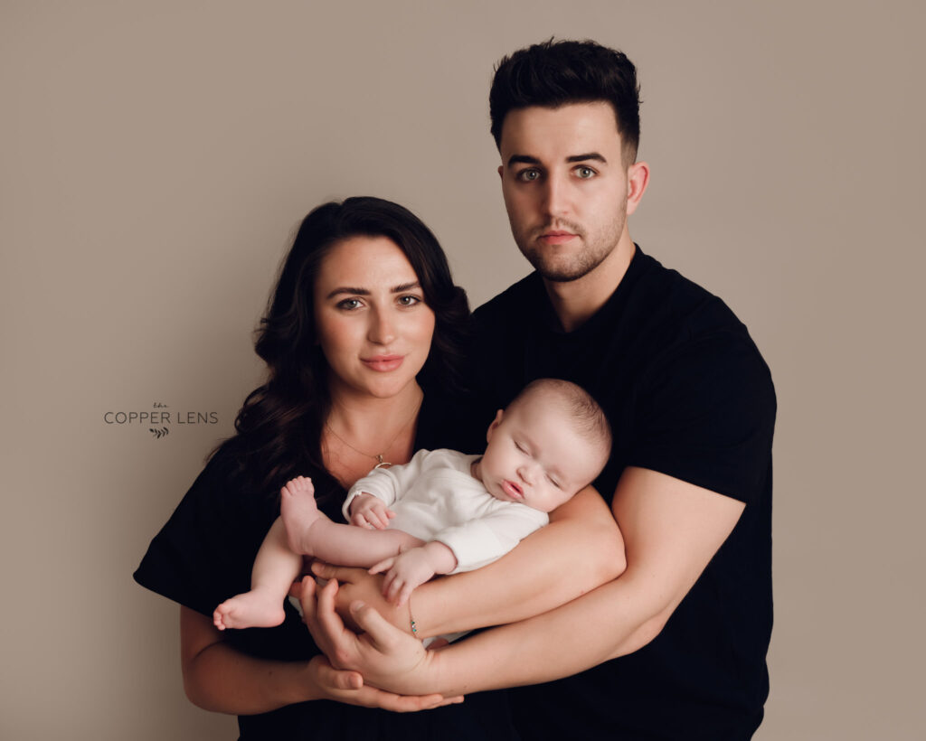 new parents holding their newborn baby while bonding