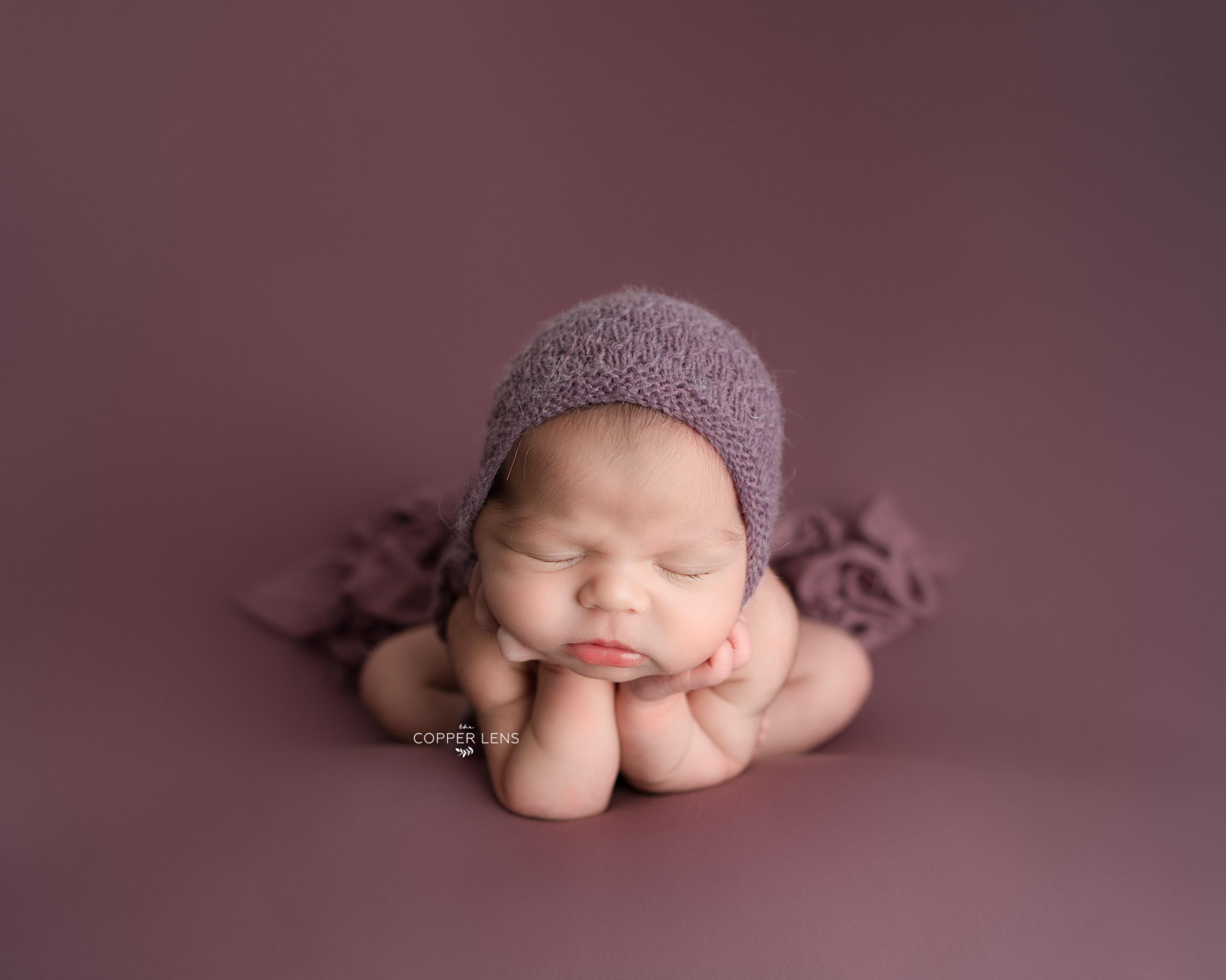 newborn baby sleeping wearing a bonnet at newborn photoshoot Swansea