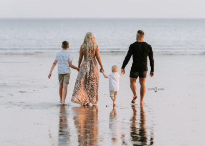 family walking on beach during family photoshoot in swansea