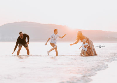 family playing on beach during Swansea photoshoot