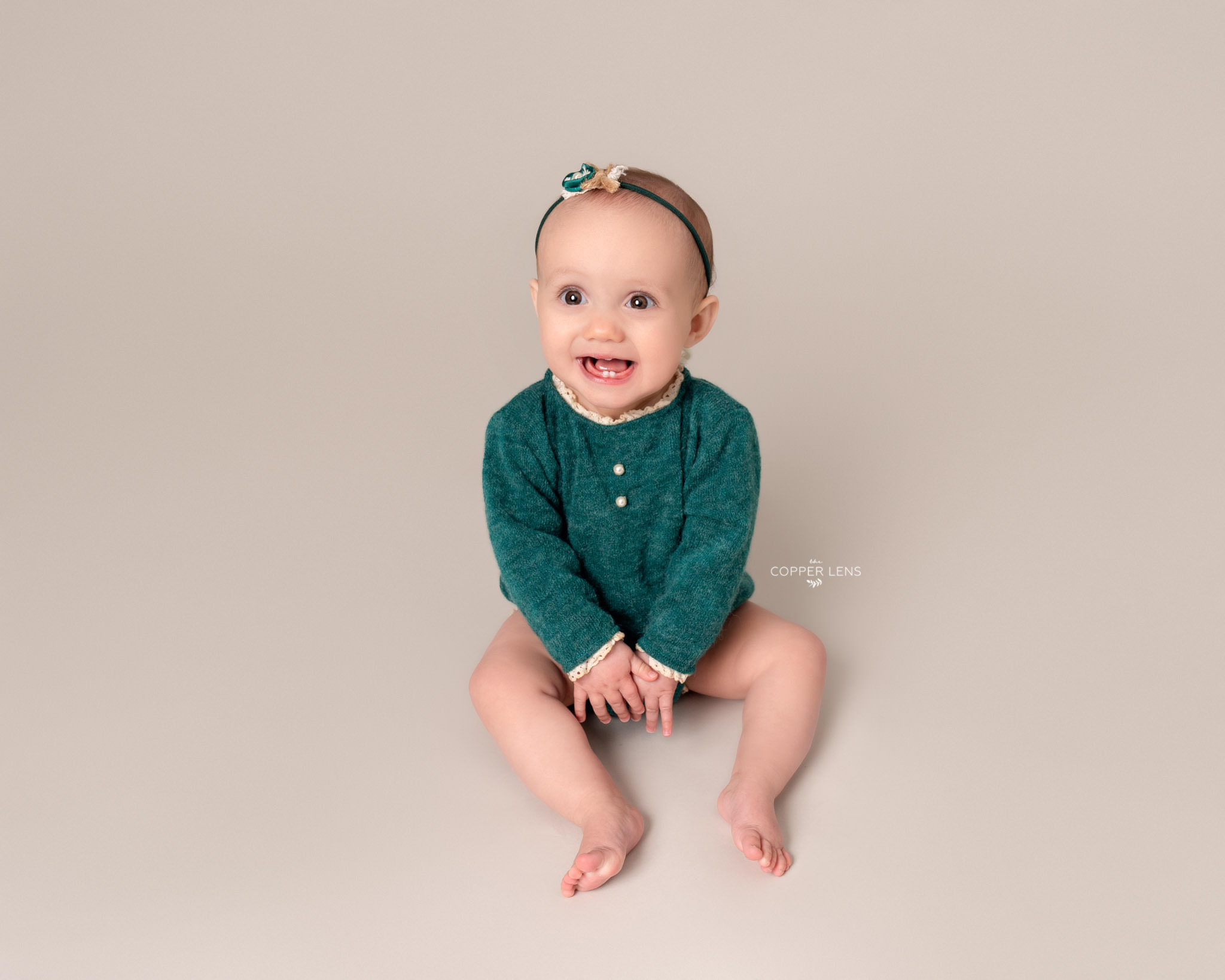baby in green outfit at sitter photographer session in swansea
